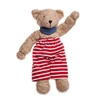 Doudou nounours en coton bio brun clair avec un pantalon rayé blanc et rouge et un châle bleu au cou.