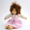 Sitting doll with brown mohair hair, brown hair, a white t-shirt with long sleeves and a pink pinafore dress.