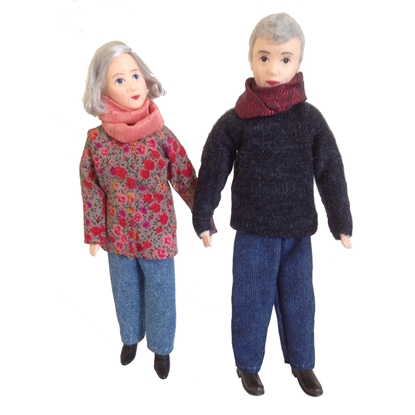 Poppen voor poppenhuis, grootouders. De grootvader draagt een blauwe wollen broek, een donkerblauwe trui en een bordeaux sjaal. De grootmoeder draagt een lichtblauwe wollen lange broek , een zalmroze zijden sjaal en een lange  vest met rode en roze bloemen.