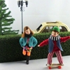 Popje voor poppenhuis, jongen met rode dikke trui speelt samen met zijn poppenhuis zusje op een skate board.