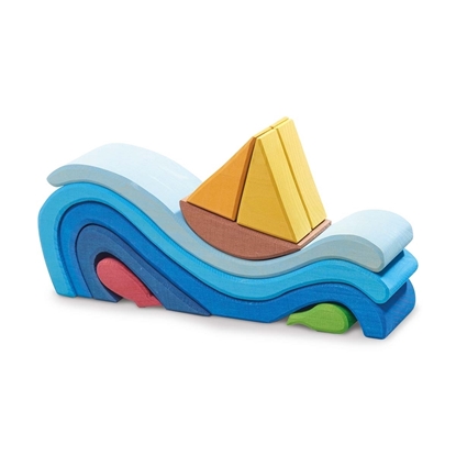 Plusieurs blocs de construction de formes et couleurs différentes représentant des vagues superposées en différentes teintes de bleu surmontées par un bateau brun à voiles jaunes.