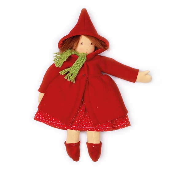 Soft 40 cm Nanchen doll with brown mohair hair and brown eyes. The Waldorf doll wears a red woolen coat and a red corduroy dress with white dots, a red woolen coat with capuchon, a green woolen scarf and red boots made of wool felt.