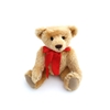 Ours en peluche mohair Nostalgie couleur or 30 cm assis avec un grand ruban rouge.