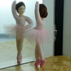 A flexible Erna Meyer doll with pink tutu and pink ballet shoes is dancing en pointe while looking  in the mirror.
