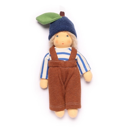 Kleine Nanchen pop met wit en blauw gestreepte trui, lange bruine broek met schouderbandjes en een blauwe muts met een groen blaadje.