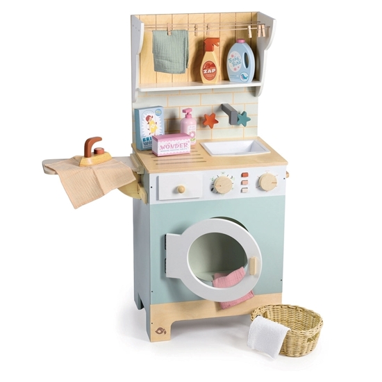 Lichtblauwe speelgoed wasmachine in hout met wasdraad, strijkplank, strijkijzer, wasmand en wasproducten.